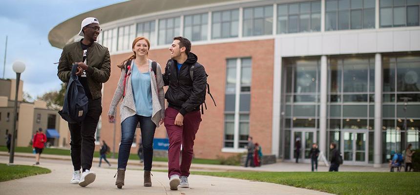 image of three students walking and smiling outside of GHH